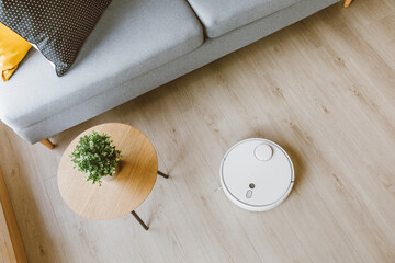 Wireless Robotic vacuum cleaner  cleaning a wooden floor in living room