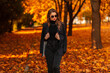 © alones - Beautiful young model girl in an elegant suit with a black sweater and a blazer walks in the park with autumn foliage