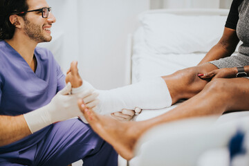 Wall Mural - Doctor helping a patient with a fractured leg