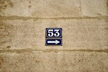 Close Up Of Blue Ceramic Plaques On Stone Wall With Arrow & Number 53