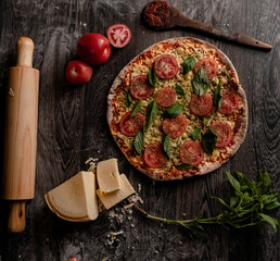 Wall Mural - Top view of a gourmet pizza and ingredients on a wooden board