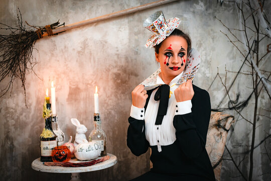 Portrait of young woman in Queen of Hearts costume with card collar