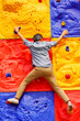 © 15Studio - Man climbing wall without grips. Businessman climb on colourful wall