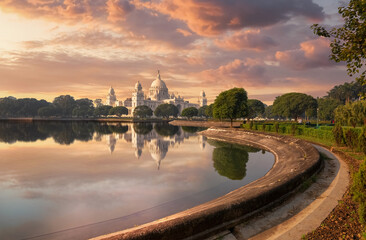 Fototapete - Victoria Memorial Kolkata with adjoining garden and lake at sunset