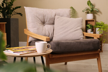 Sticker - Comfortable armchair near wooden coffee table in room. Interior design