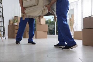 Canvas Print - Moving service employees carrying armchair in room, closeup