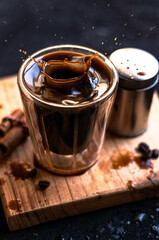 Poster - Double espresso coffee mug with cinnamon sticks and coffee beans on a wooden board