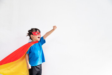 Wall Mural - Little child girl plays superhero. Child on the white background. Girl power concept