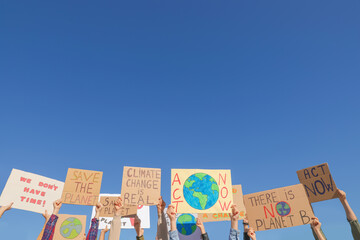 group of people with posters protesting against climate change outdoors, closeup