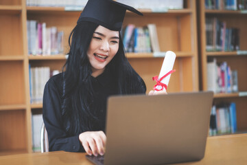 Young Asian female university graduate with degree celebrates virtual graduation through video call