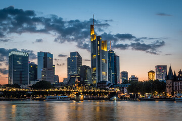 Illuminated skyline of Frankfurt at the bank of Main river after sunset