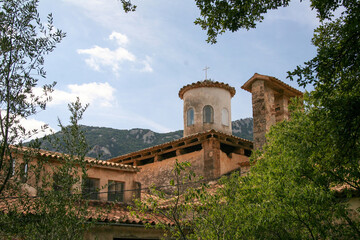 Wall Mural - Beautiful old ancient monastery of Santuari de Lluc against a blue cloudy sky