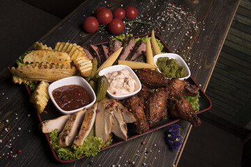 Poster - Meat assortment of fried chicken wings, beef, and pork decorated with lettuce, cherry tomatoes