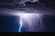 A bolt of lightning strikes in a storm. Thunderstorm in the night sky