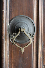 Poster - Vertical shot of an old vintage knocker on the wooden door