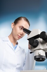 Wall Mural - Scientist woman doctor analyzing test results using medical microscope