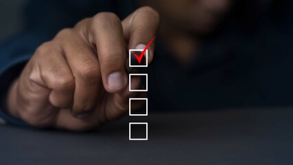 Businessman's hand using a check pen Choose the right one for the best option.