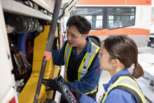 Mechanics Fixing Bus Engine In Maintenance Facility