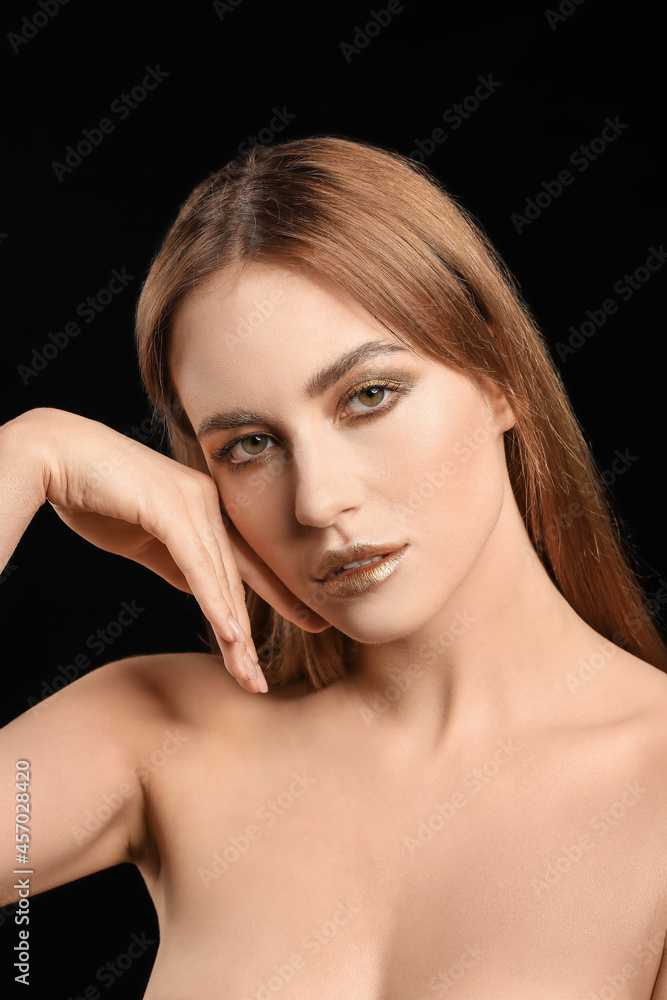 Beautiful young woman with  golden makeup on black background