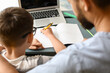 © Pixel-Shot - Little boy with his father doing lessons at home