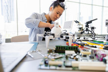 Female Engineer Assembling Robotics In Laboratory