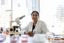 Portrait Confident Female Scientist At Microscope In Laboratory