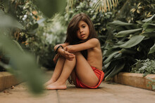 Mowgli Indian Little Girl In A Loincloth Hides Hiding In Tropics Green Forest Background. High Quality Photo