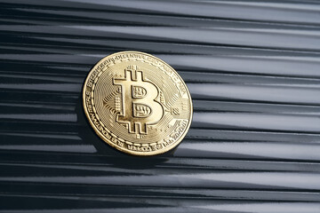 Gold bitcoin cryptocurrency coin on an abstract background.