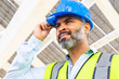 © ADDICTIVE STOCK - Hispanic engineer putting on safety helmet against solar power station