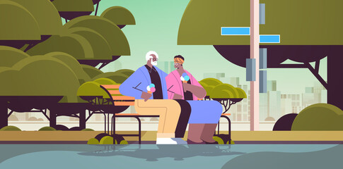 senior couple sitting on bench and eating ice cream happy african american grandparents spending time together in park