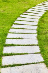 White granite walkway slabs patterned in green lawns at the garden