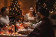 © Syda Productions - holidays, party and celebration concept - multiethnic group of happy friends having christmas dinner at home and drinking wine
