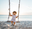 happy Little girl swinging at the beach