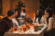 © Syda Productions - holidays and celebration concept - multiethnic group of happy friends having christmas dinner at home