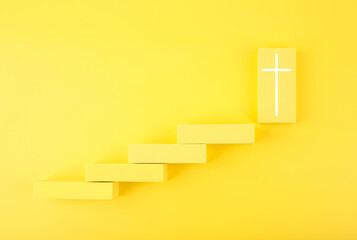 Modern biblical creative religious concept of steps or ladder to faith and God. Yellow steps to cross at the last step. 