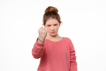 severe little girl shaking fist and looking at camera. human emotions, facial expression concept
