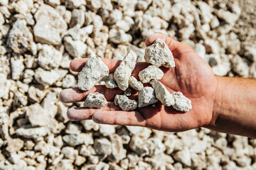 top view hands with white stones. rough light, close up