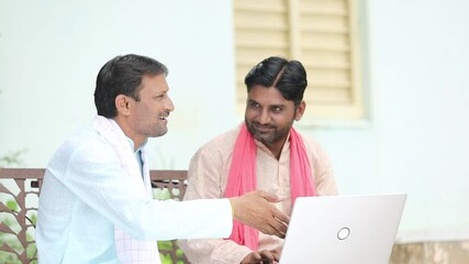 Technology concept : Indian farmers using laptop at home.