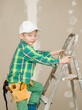 © Ermolaev Alexandr - Young boy dressed like a worker stands on a ladder