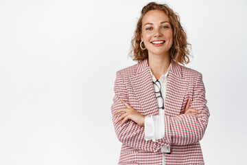 Young professional business woman cross arms on chest, smiling and looking like real professional, white background