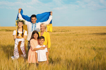 Poster - Happy family with national flag of Ukraine and treat in field. Space for text