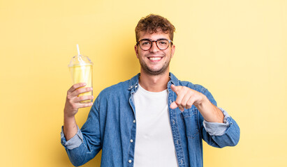 young handsome man pointing at camera choosing you. milkshake concept