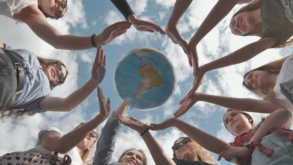 earth conservation concept. 11 girls surround the rotating earth globe with their palms.