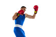 Portrait of one professional boxer in blue uniform training isolated over white background. Uppercut punch