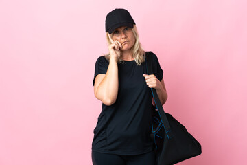 Wall Mural - Middle age woman with sport bag isolated on pink background thinking an idea