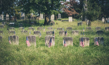 Grave In The Cemetery American Flags