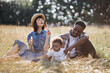 © sofiko14 - Beautiful caucasian mother and handsome african father blowing soap bubbles during summer picnic with little son on nature. Family having fun outdoors. Relaxation concept.