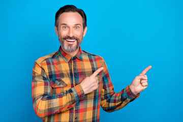 Sticker - Photo portrait man smiling pointing finger copyspace wearing checkered shirt isolated vibrant blue color background