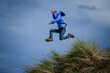 Boy jumping from dune in the air