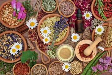 Canvas Print - Essential oil preparation with herbs and flowers used in natural herbal  medicine remedies. Plant based nature health care concept. Top view on rustic wood. 